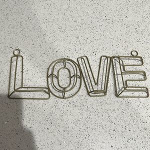 Gold metal 3D sign that says love